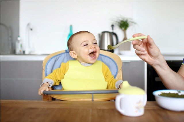 Enfant qui prend son repas dans une chaise haute