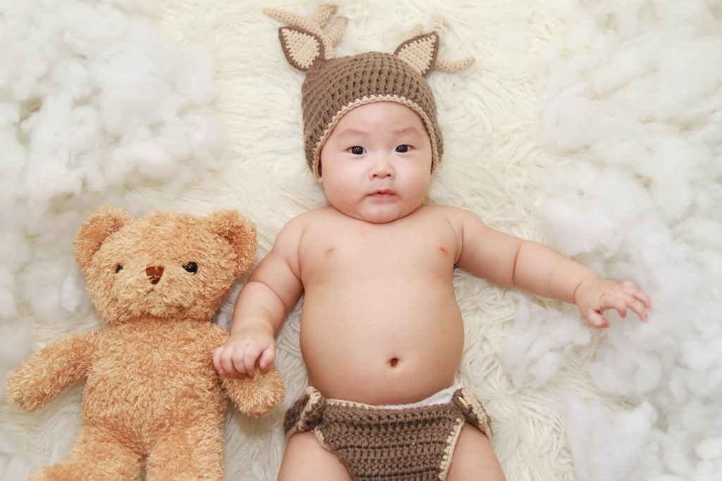 Bébé avec son doudou en ours en peluche